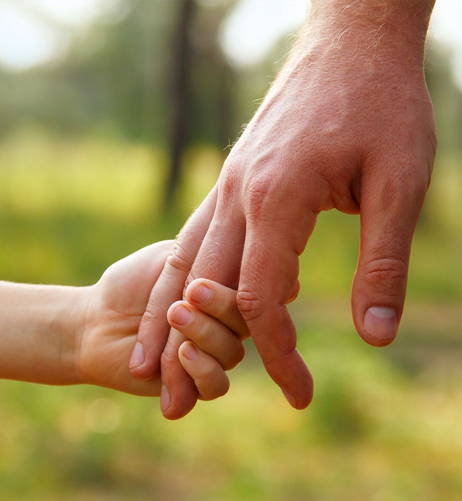 ein Kind und ein Mann halten Händchen
