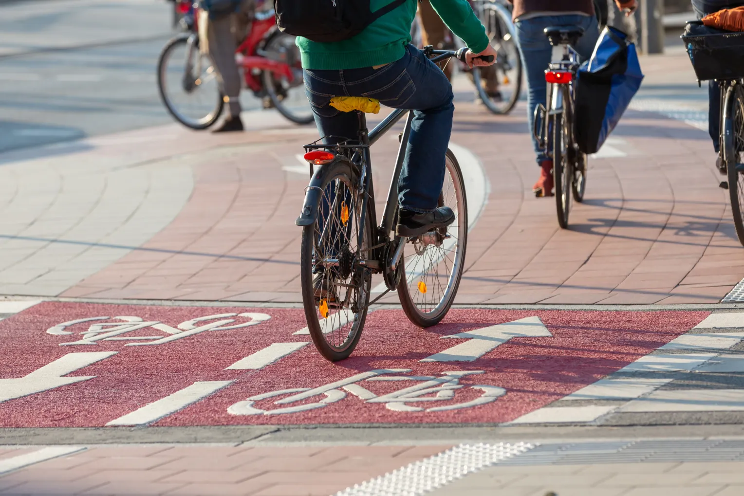Mehrere Radfahrer fahren auf einem rot gefärbten, zweispurigen Radweg.