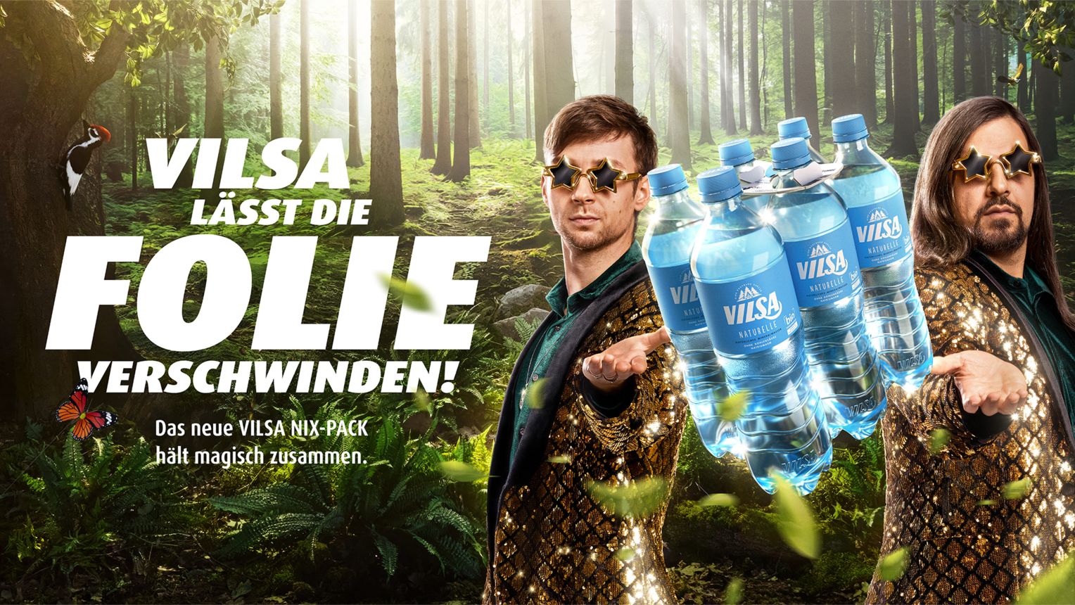 Werbegrafik von VILSA mit dem Slogan: „VILSA lässt die Folie verschwinden!“ Im Zentrum stehen zwei Männer mit glitzernden Jacken und Sternen-Sonnenbrillen, die wie Magier wirken. Sie präsentieren ein schwebendes Sixpack VILSA-Wasserflaschen, das ohne Schrumpffolie zusammengehalten wird. Im Hintergrund ein sonnendurchfluteter, dichter Wald. Links im Bild ein Specht an einem Baum, ein Schmetterling und die Aussage: „Das neue VILSA NIX-PACK hält magisch zusammen.“ Die Szene vermittelt eine Verbindung von Magie und Umweltschutz.