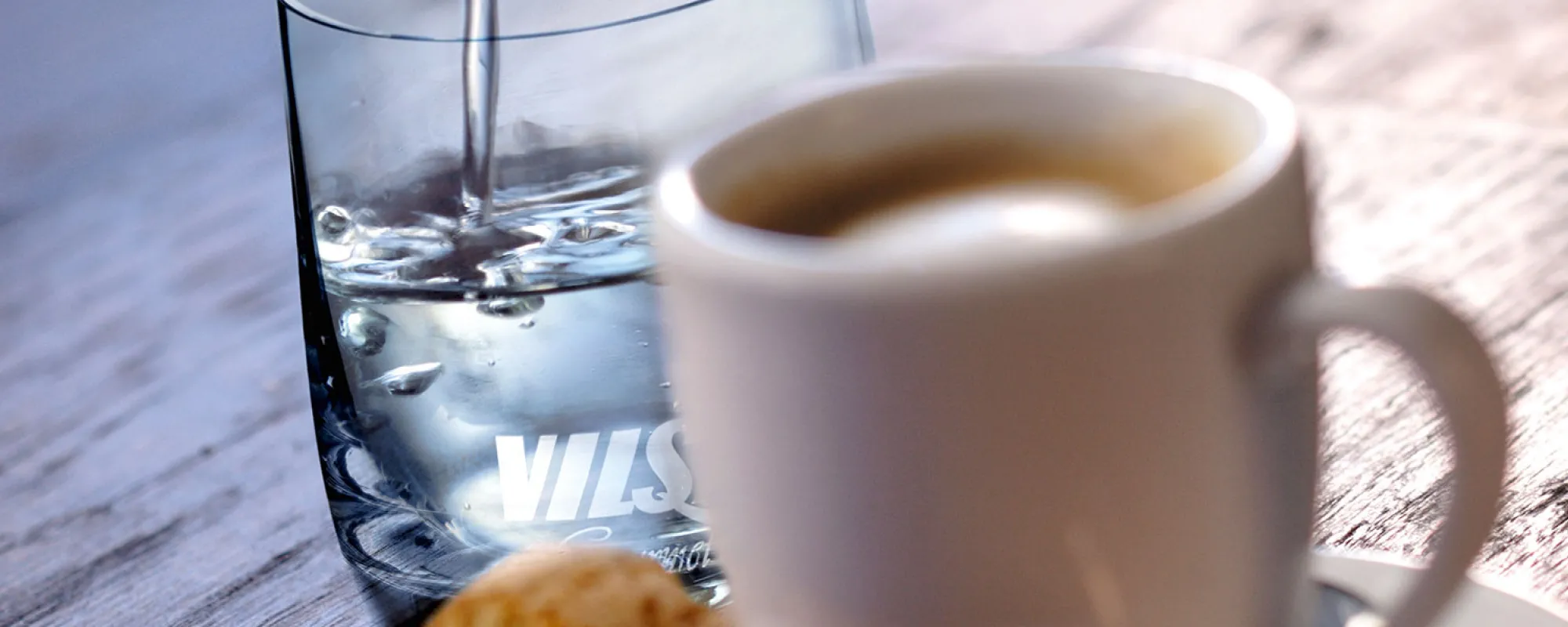 VILSA Mineralwasser neben einer Tasse Kaffee