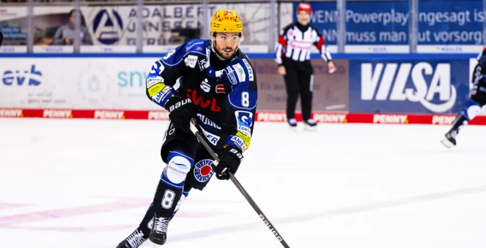 Eishockeyspieler läuft mit dem Puck über das Eis, im Hintergrund befindet sich eine große VILSA-Werbebande.