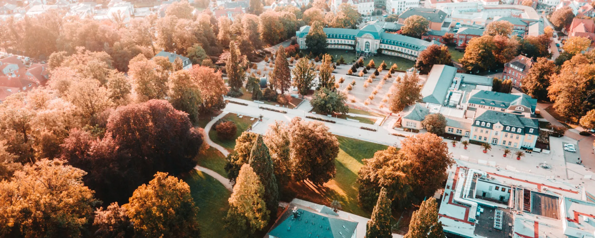 Luftaufnahme von Bad Nenndorf mit Kurpark, historischen Gebäuden und herbstlich gefärbten Bäumen.