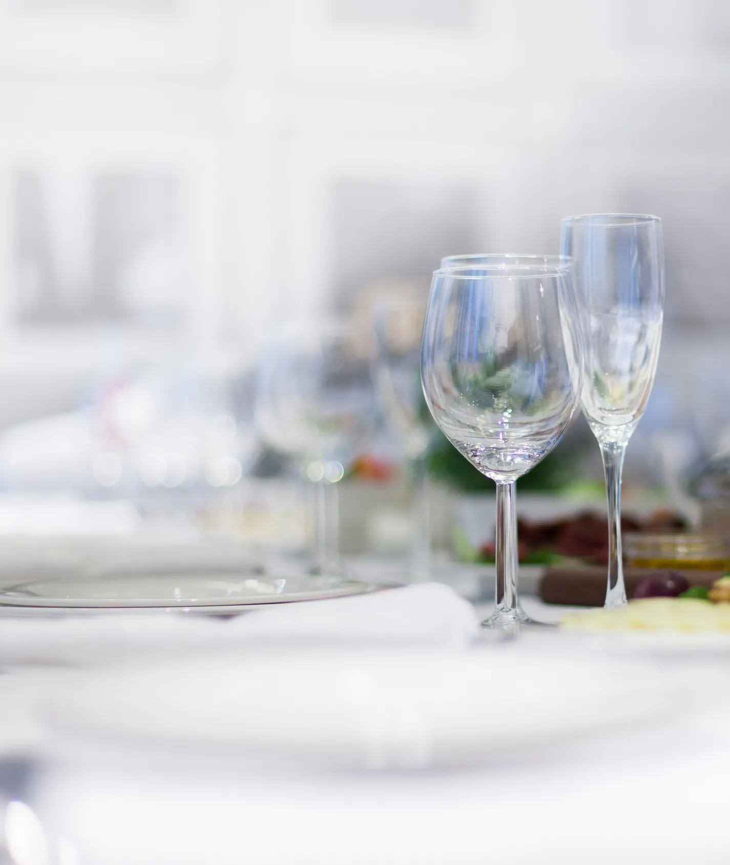 Tisch mit weißer Decke mit Wasserglas und Sektglas