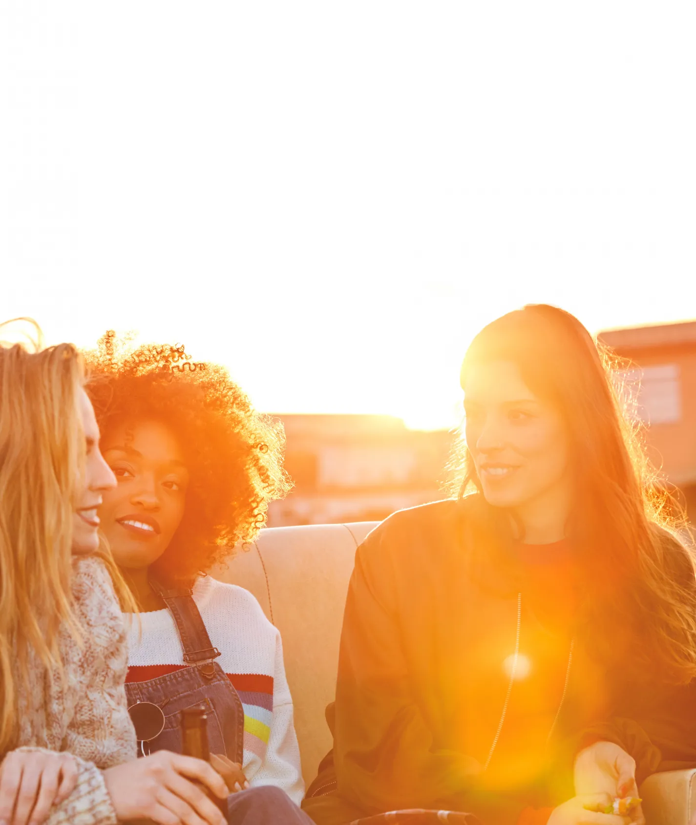 drei junge Frauen unterhalten sich im Sonnenschein