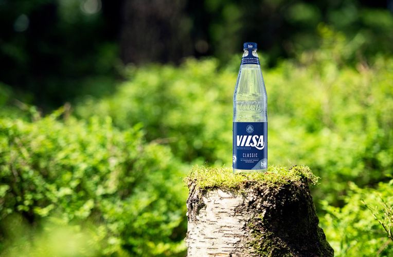 VILSA Mineralwasser classic Glas 0,7l auf einem Baumstumpf in der Natur