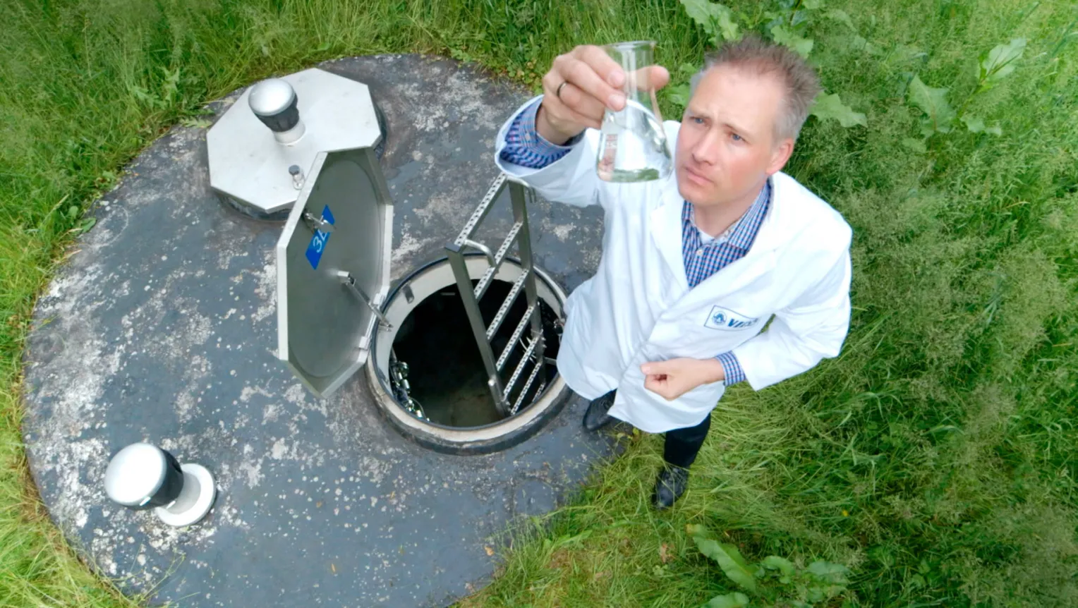 Labormitarbeiter entnimmt Mineralwasserprobe