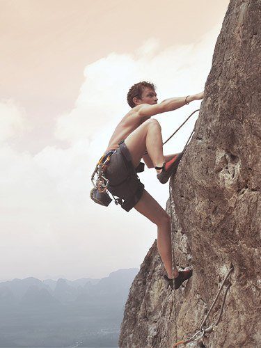 vilsa-h2obst-klettern-mann-hero-mobile junger Mann klettert oberkörperfrei ein Berg hoch