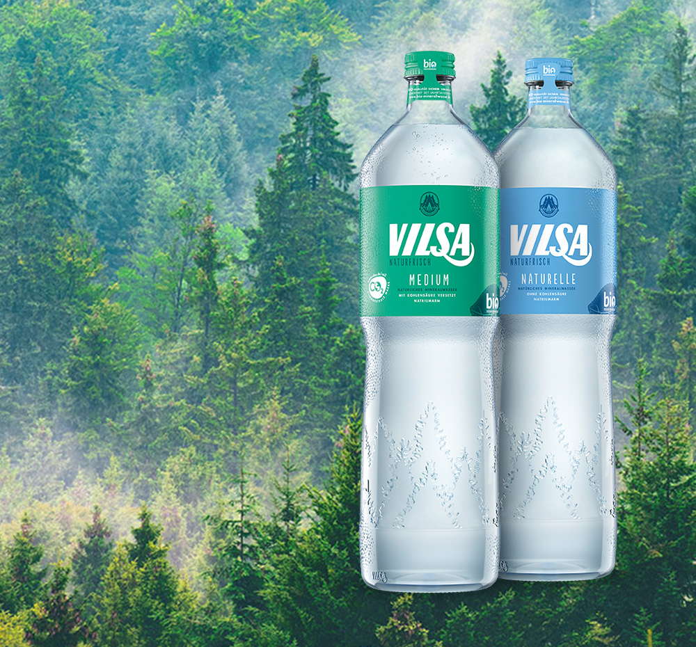 Genießerflasche Naturelle und Medium Glas 1,0l vor einem Tannenwaldhintergrund
